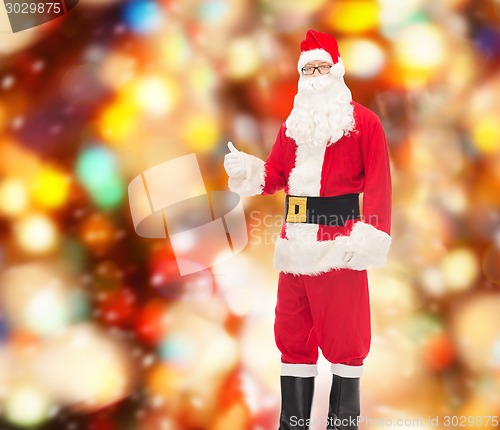 Image of man in costume of santa claus showing thumbs up