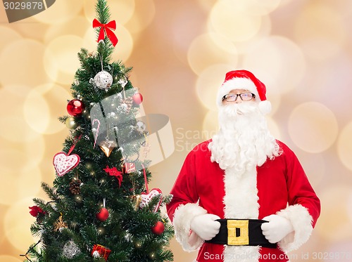 Image of man in costume of santa claus with christmas tree