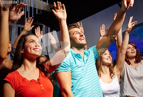 Image of smiling friends at concert in club