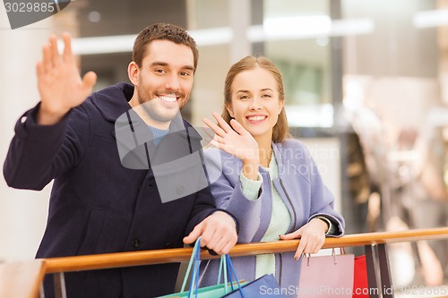 Image of happy young couple with shopping bags in mall