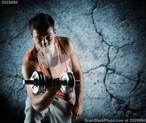 Image of young man with dumbbell flexing biceps