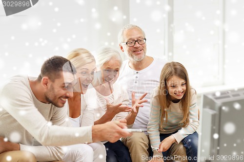 Image of happy family watching tv at home