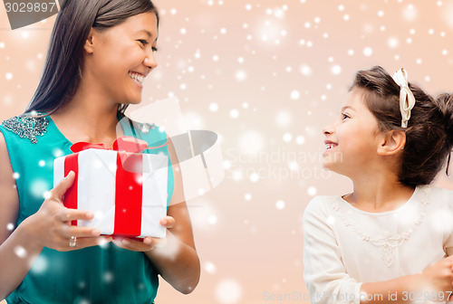 Image of happy mother and child girl with gift box