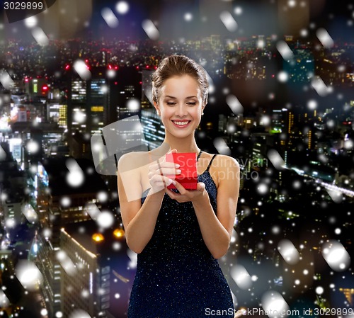 Image of smiling woman holding red gift box