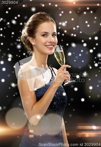 Image of smiling woman holding glass of sparkling wine