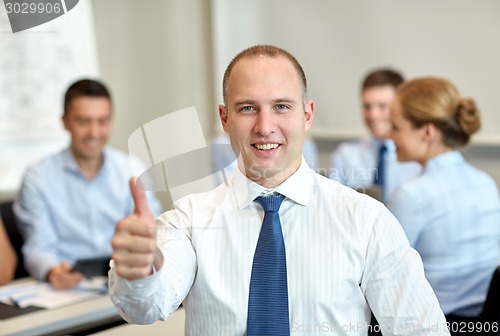 Image of group of smiling businesspeople meeting in office