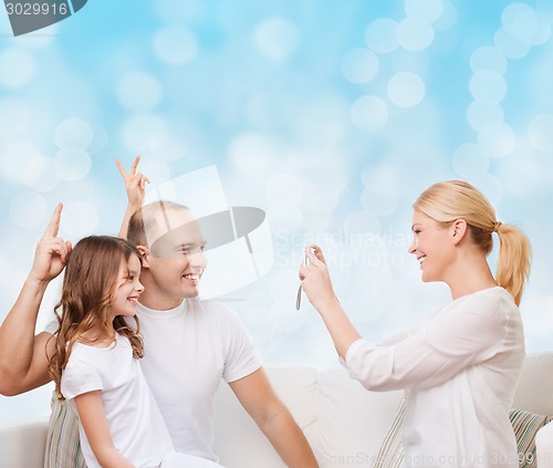 Image of happy family with camera at home