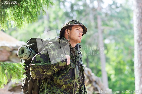 Image of young soldier with backpack in forest