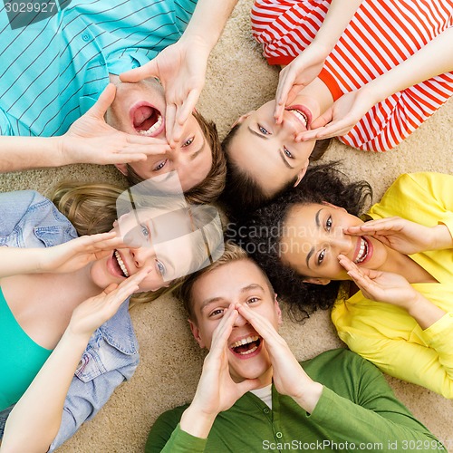 Image of smiling people lying down on floor and screaming