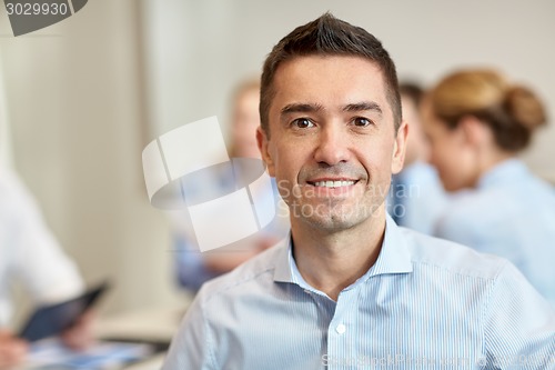 Image of group of smiling businesspeople meeting in office