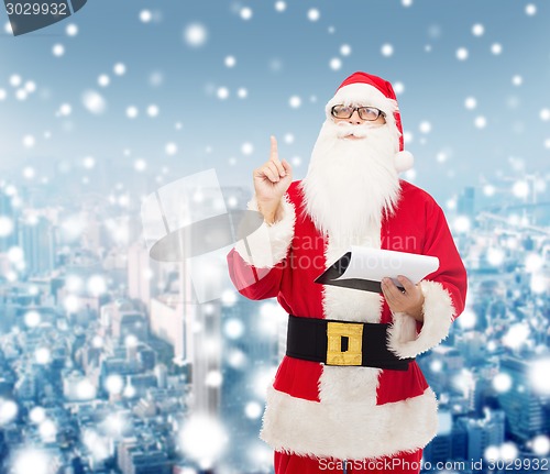 Image of man in costume of santa claus with notepad