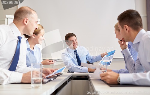 Image of group of smiling businesspeople meeting in office