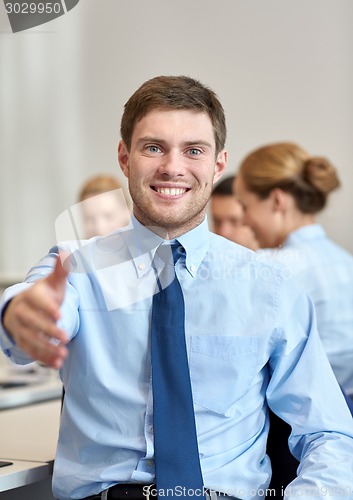 Image of group of smiling businesspeople meeting in office