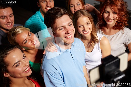 Image of friends with smartphone taking selfie in club