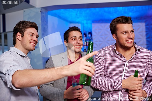 Image of group of male friends with beer in nightclub