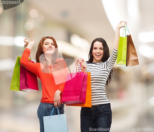 Image of two smiling teenage girls with shopping bags