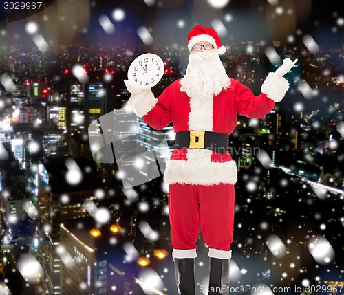 Image of man in costume of santa claus with clock