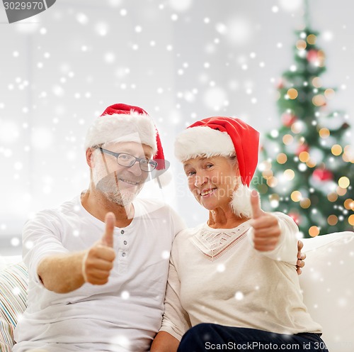Image of happy senior couple in santa helper hats
