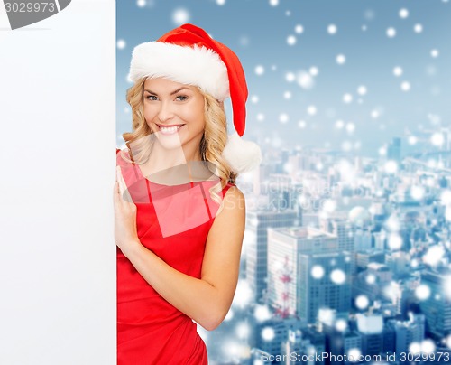 Image of smiling young woman in santa hat with white board