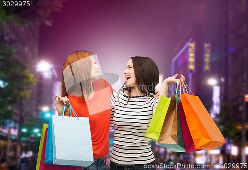 Image of two smiling teenage girls with shopping bags