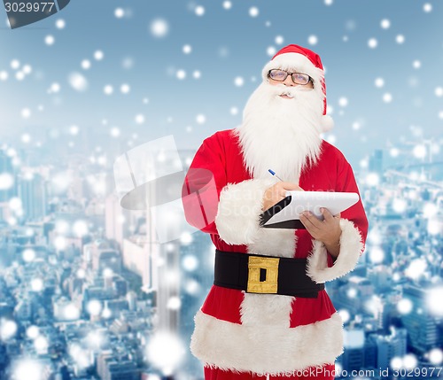 Image of man in costume of santa claus with notepad