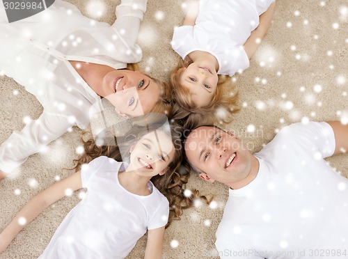 Image of parents and two girls lying on floor at home