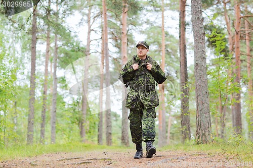 Image of young soldier with backpack in forest