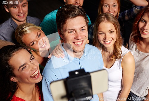 Image of friends with smartphone taking selfie in club