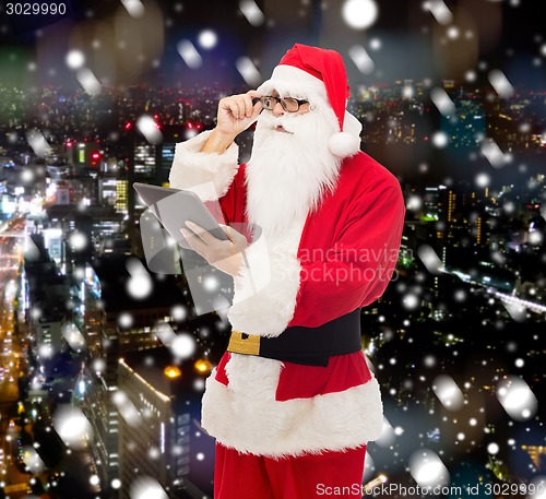 Image of man in costume of santa claus with tablet pc