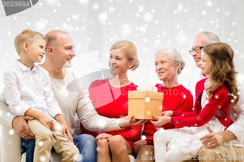 Image of smiling family with gift at home