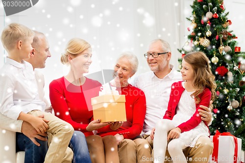 Image of smiling family with gifts at home