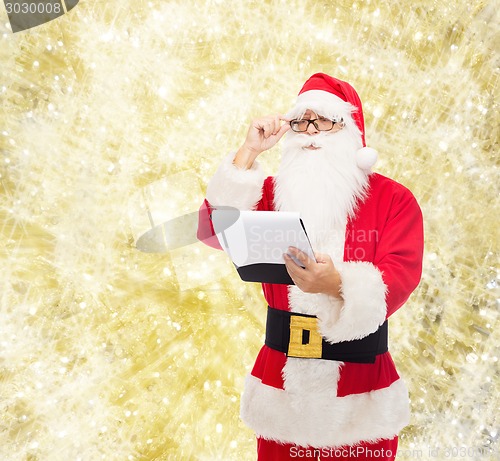 Image of man in costume of santa claus with notepad