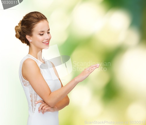 Image of smiling woman in white dress with diamond ring