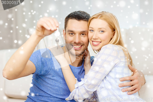 Image of smiling couple holding keys at home