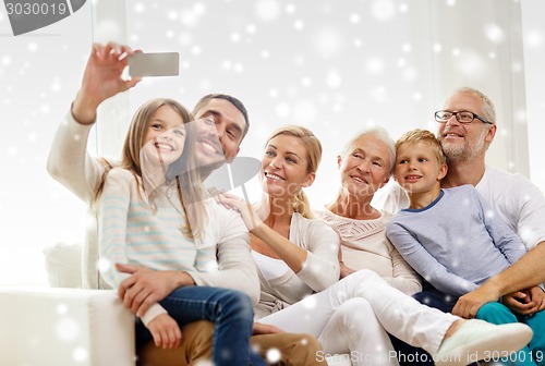 Image of happy family taking selfie with smartphone at home