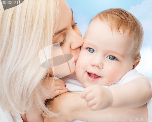 Image of happy mother kissing smiling baby