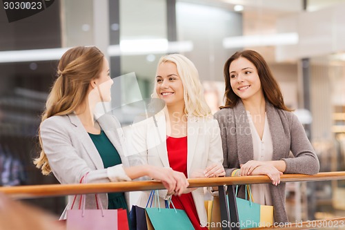 Image of happy young women with shopping bags in mall