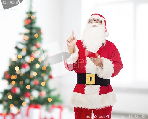 Image of man in costume of santa claus with notepad