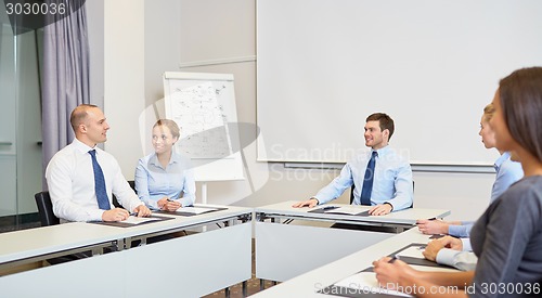 Image of group of smiling businesspeople meeting in office