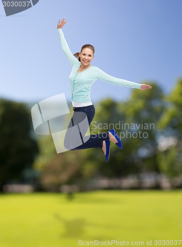 Image of smiling young woman jumping in air