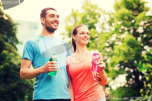 Image of smiling couple with bottles of water outdoors