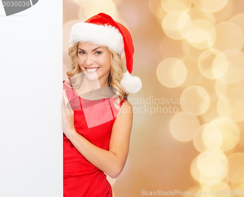 Image of smiling young woman in santa hat with white board