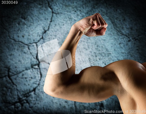 Image of close up of young man flexing and showing biceps