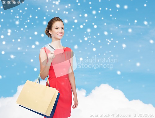 Image of smiling woman with shopping bags and plastic card