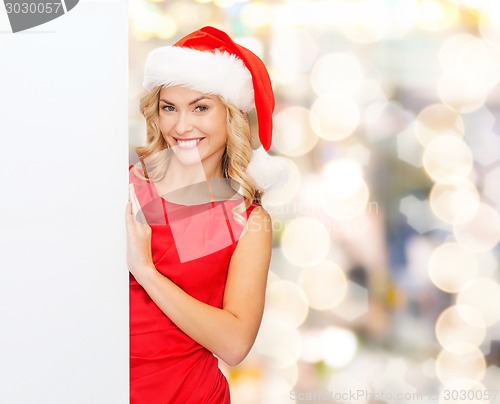 Image of smiling young woman in santa hat with white board