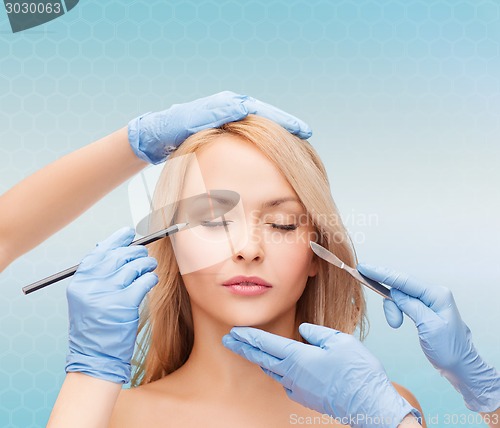 Image of woman face with hands holding marker and scalpel