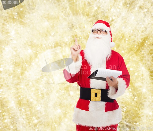 Image of man in costume of santa claus with notepad