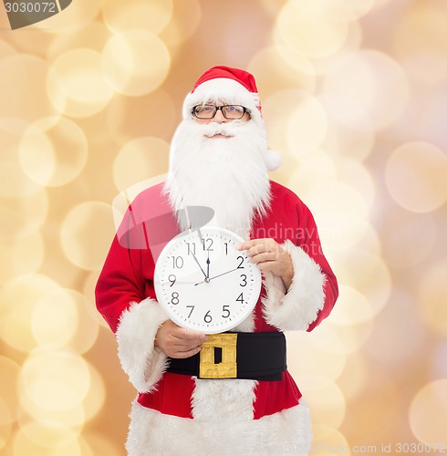 Image of man in costume of santa claus with clock