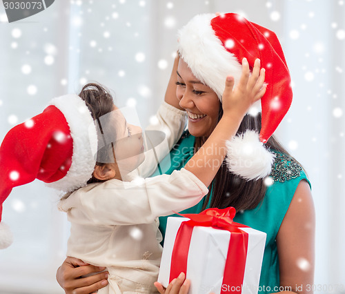 Image of happy mother and child girl with gift box