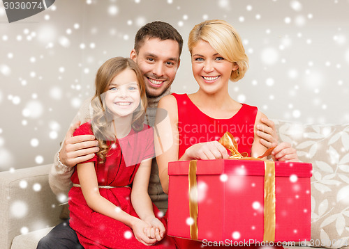 Image of smiling family holding gift box